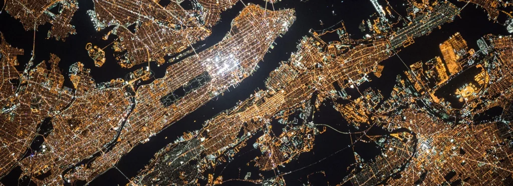 A city at night seen from above, its streets lit up