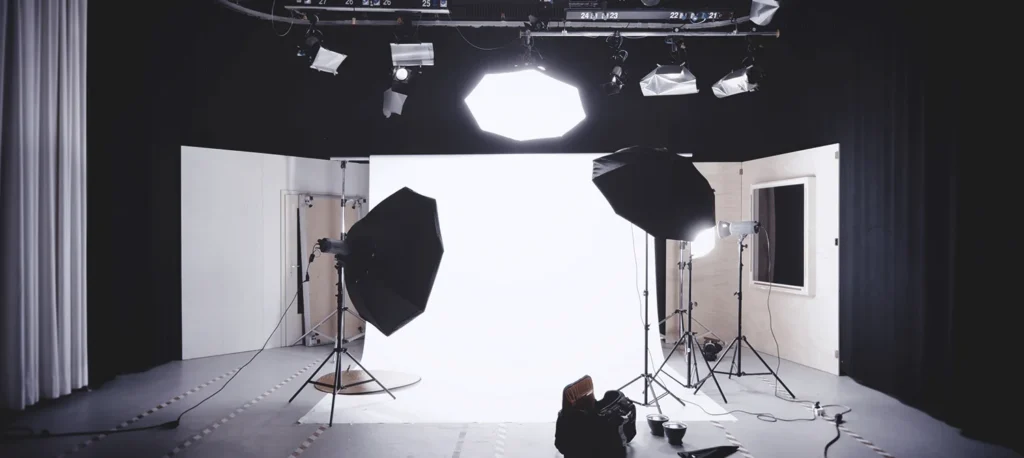An empty photo studio with softboxes and a white backdrop