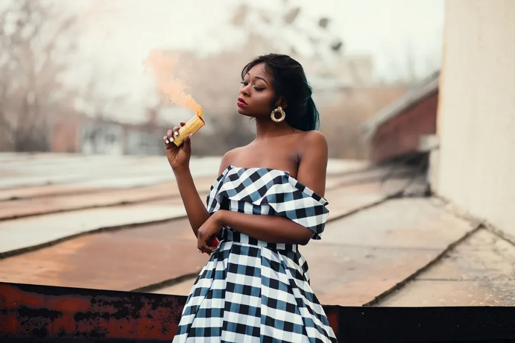A creator posing for a photo in a striped dress on a city street